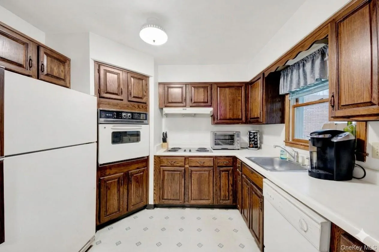 Kitchen featuring white appliances, light flooring, and light countertops Kitchen featuring white appliances, light flooring, and light countertops