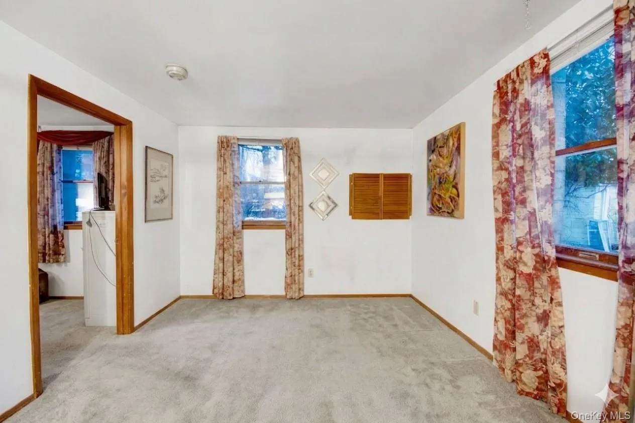 Unfurnished room featuring light carpet and baseboards Unfurnished room featuring light carpet and baseboards