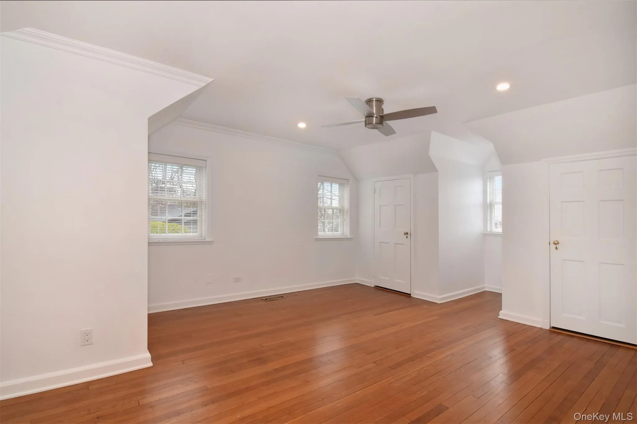Bedroom featuring lofted ceiling, hardwood / wood-style floors, recessed lighting, ceiling fan, and wonderful closet space. Note the numbers of windows! Bedroom featuring lofted ceiling, hardwood / wood-style floors, recessed lighting, ceiling fan, and wonderful closet space. Note the numbers of windows!