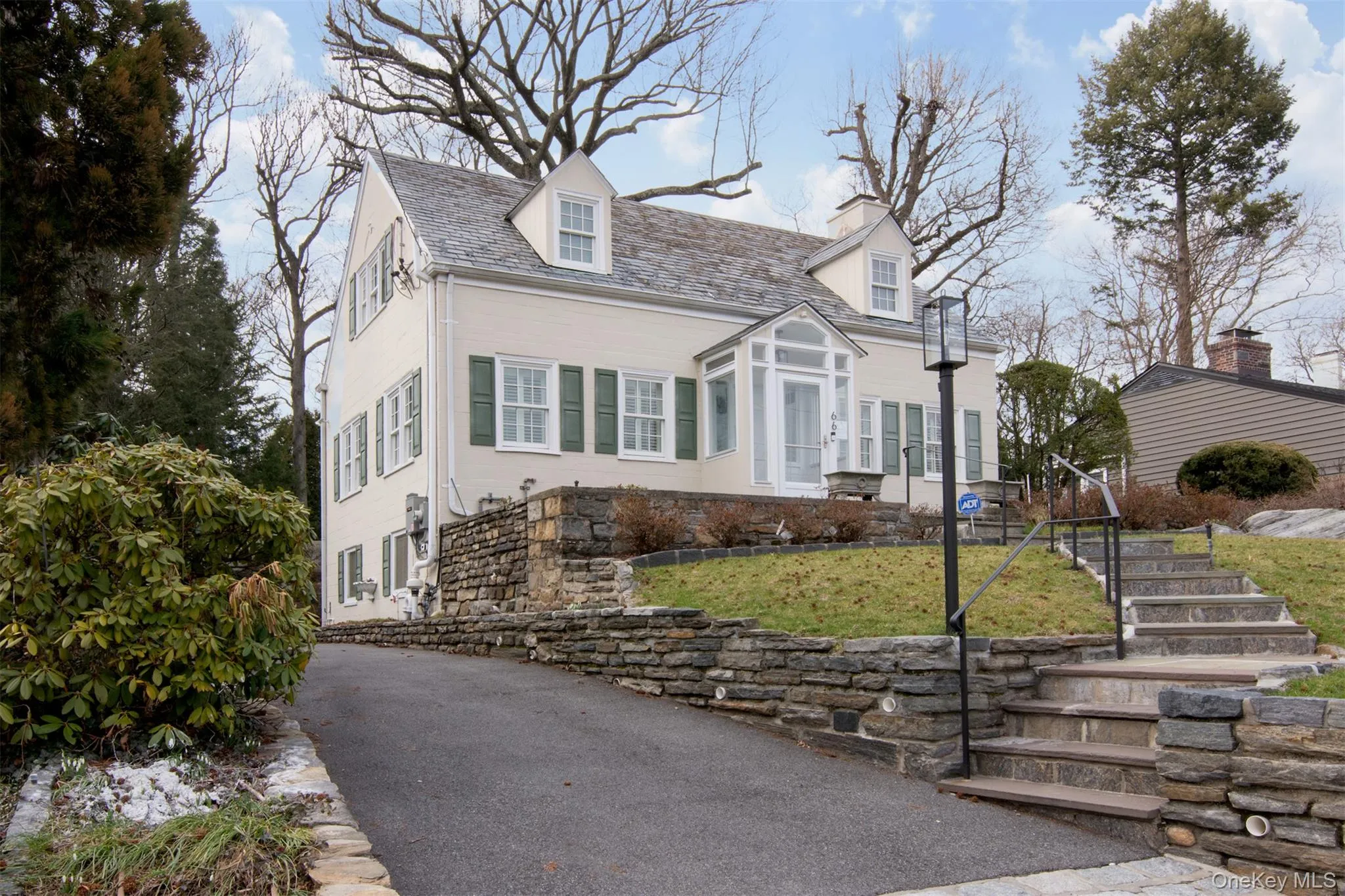 Cape cod house featuring a front lawn,with stone wall Cape cod house featuring a front lawn,with stone wall