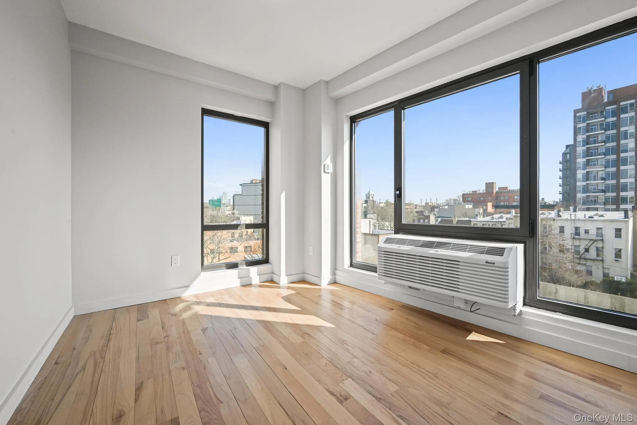 Bedroom featuring light wood-type flooring and a view of city Bedroom featuring light wood-type flooring and a view of city