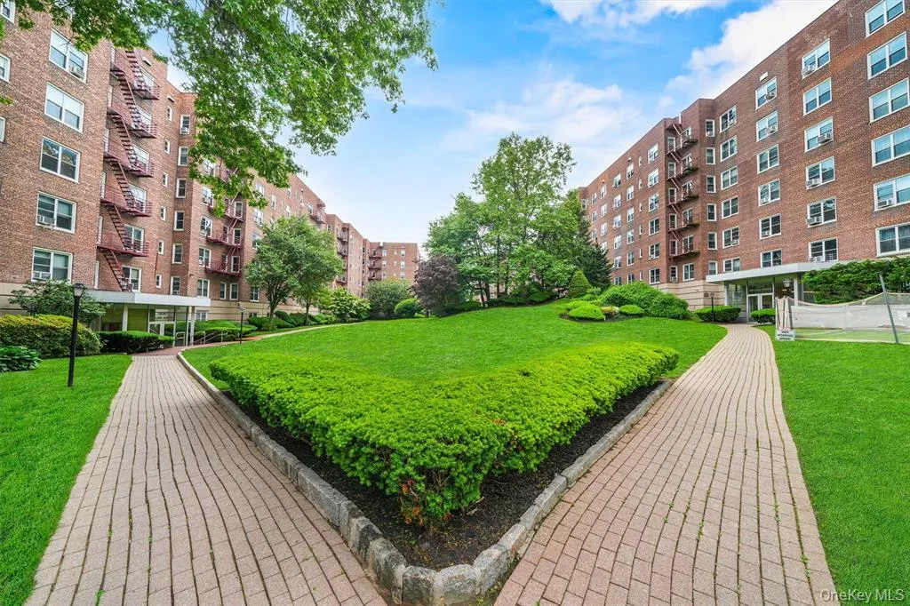 Expansive central lawn bordered by two brick paver walkways Expansive central lawn bordered by two brick paver walkways