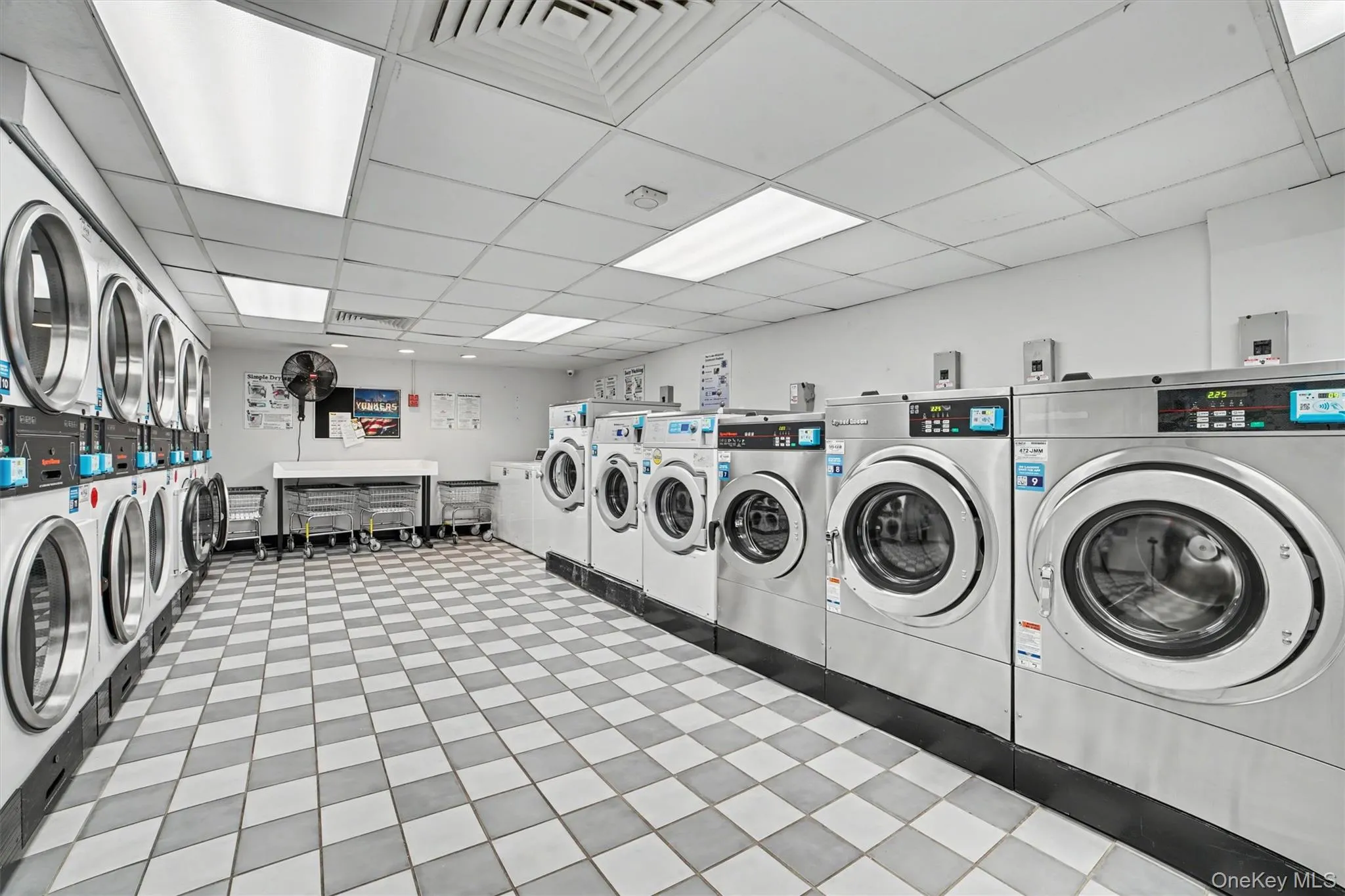Spacious laundry facility featuring numerous front-loading washing machines and dryers Spacious laundry facility featuring numerous front-loading washing machines and dryers
