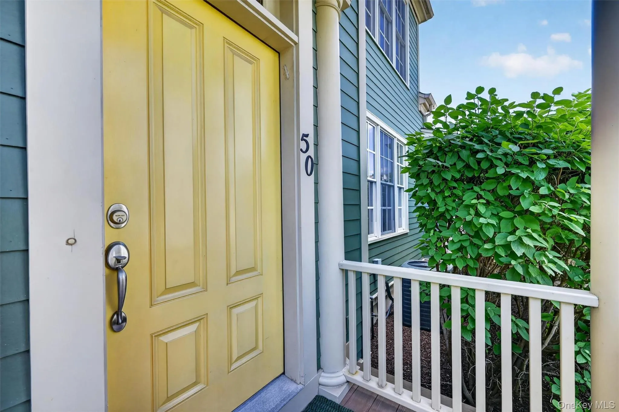 A cheerful yellow front door and covered porch create a warm first impression before stepping inside. A cheerful yellow front door and covered porch create a warm first impression before stepping inside.