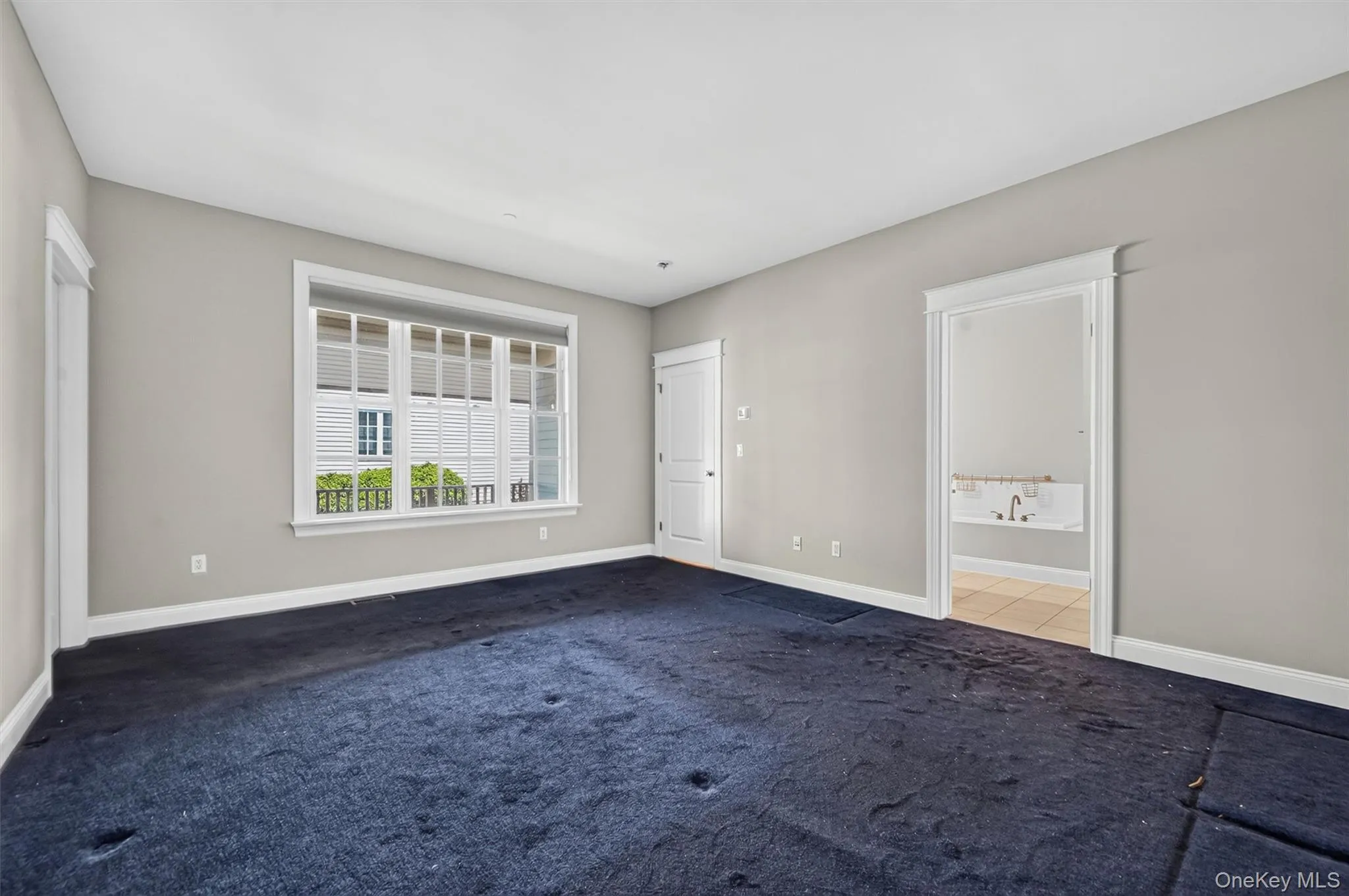 The freshly painted main-level primary suite offers generous space, large windows, and direct access to the ensuite bathroom. New carpeting would easily refresh the room and give it a whole new feel. The freshly painted main-level primary suite offers generous space, large windows, and direct access to the ensuite bathroom. New carpeting would easily refresh the room and give it a whole new feel.