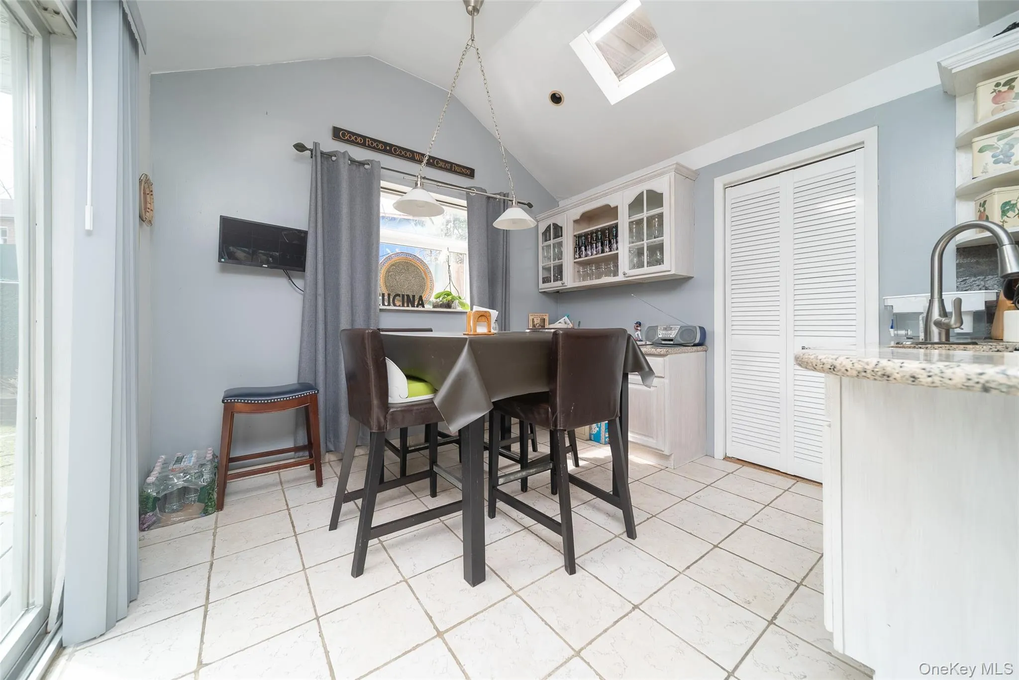 Dining area featuring a skylight and light tile patterned floors Dining area featuring a skylight and light tile patterned floors