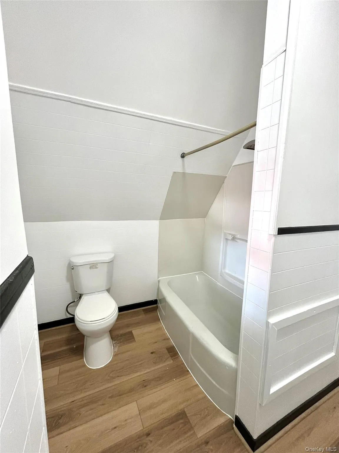 Full bathroom with wood finished floors and vaulted ceiling Full bathroom with wood finished floors and vaulted ceiling