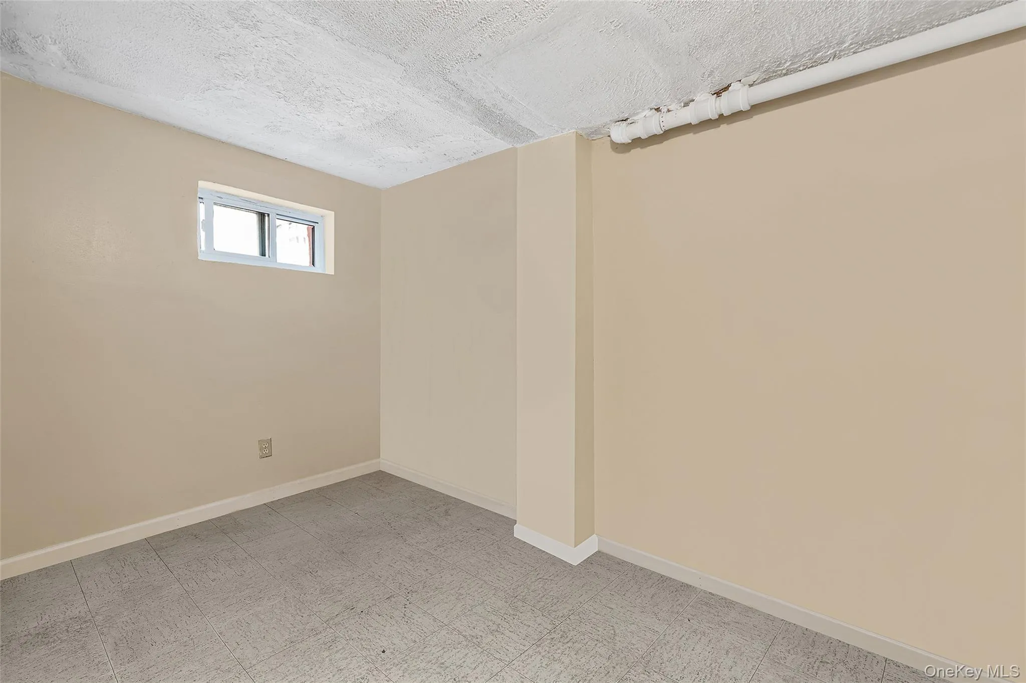 Below grade area featuring baseboards and a textured ceiling Below grade area featuring baseboards and a textured ceiling