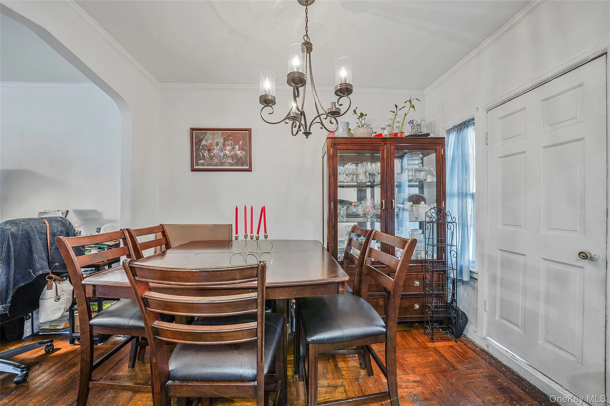 Dining room with ornamental molding, a chandelier, and arched walkways Dining room with ornamental molding, a chandelier, and arched walkways