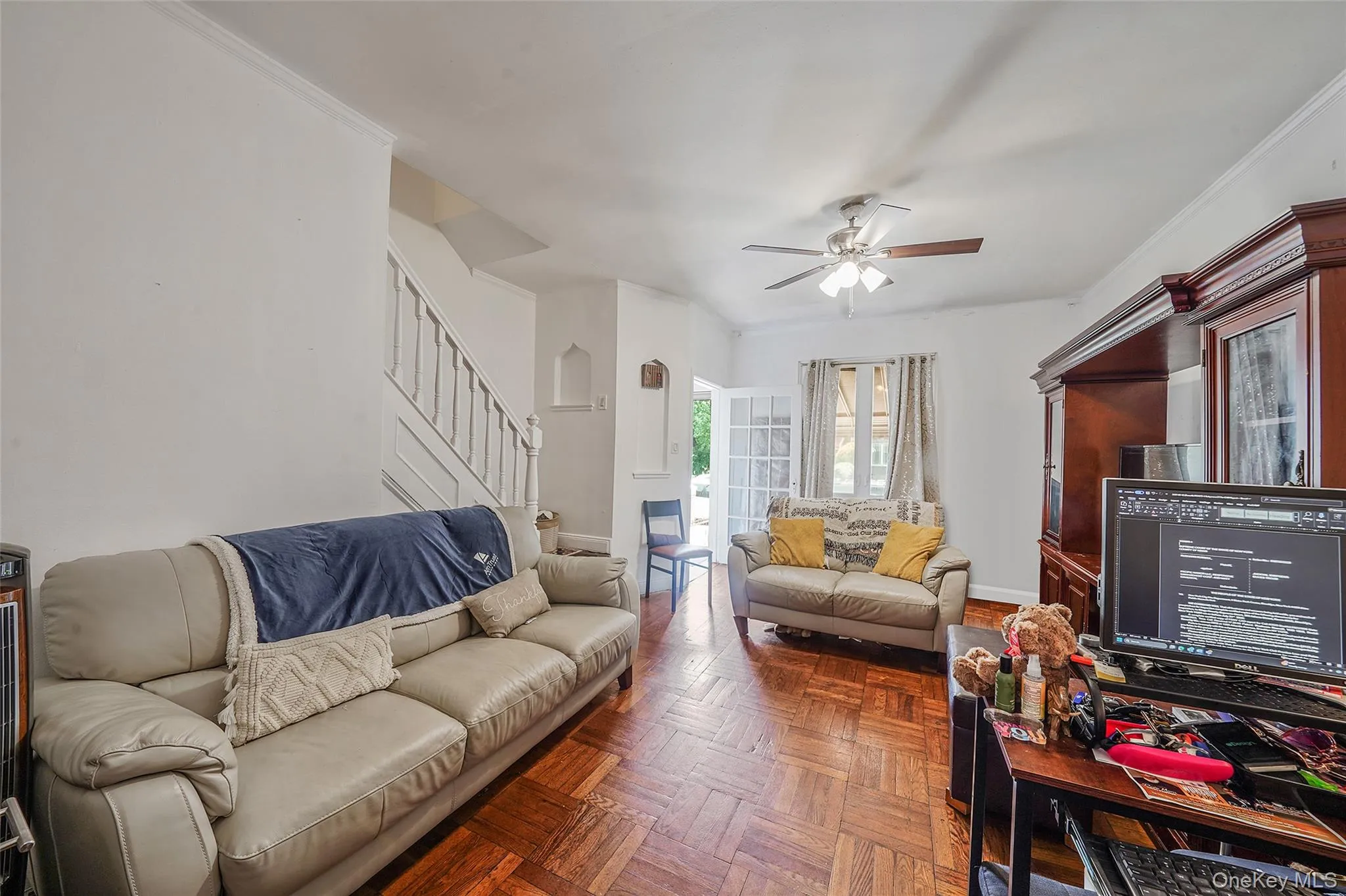 Living room featuring stairs and a ceiling fan Living room featuring stairs and a ceiling fan