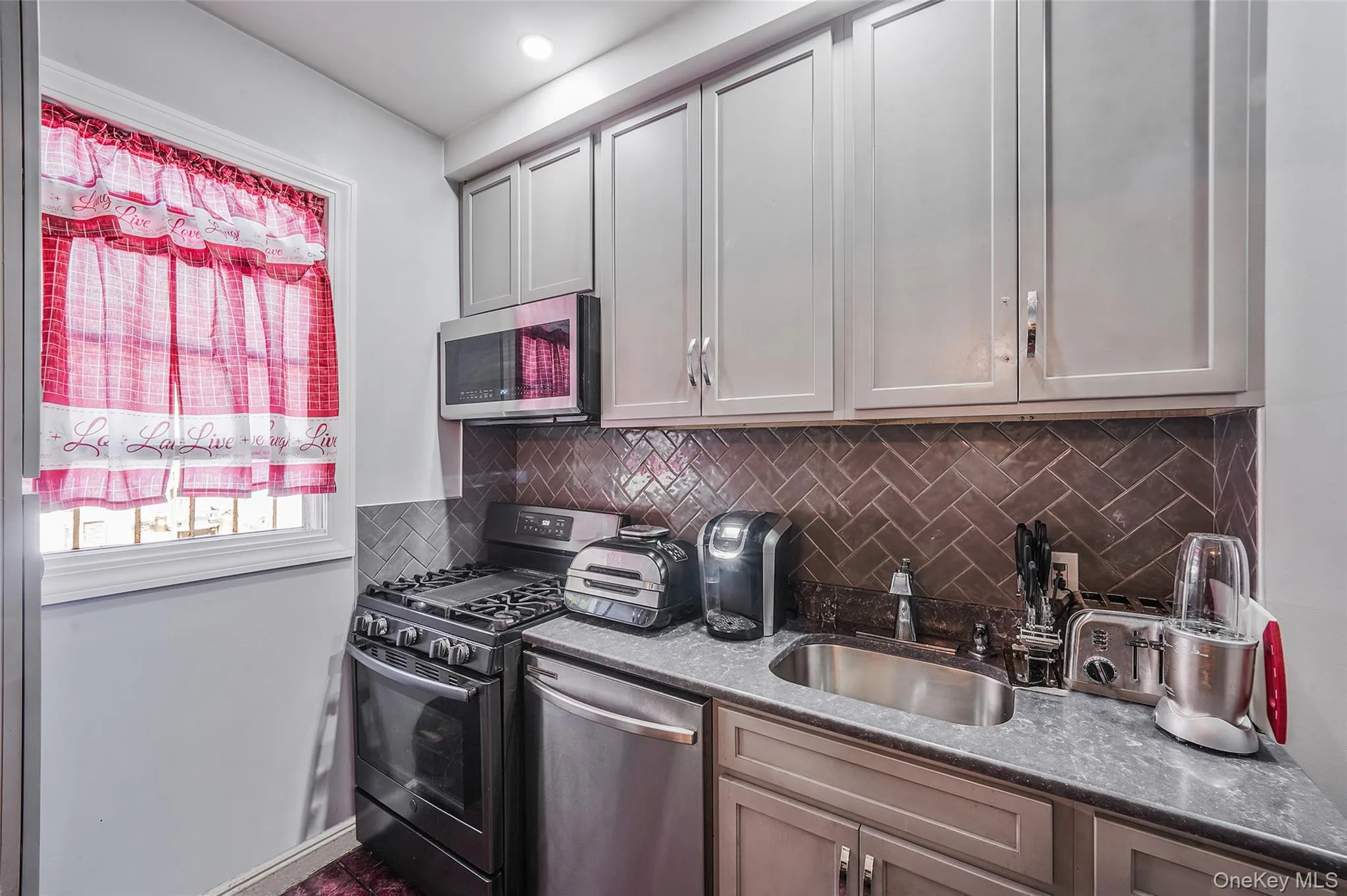 Kitchen featuring appliances with stainless steel finishes and tasteful backsplash Kitchen featuring appliances with stainless steel finishes and tasteful backsplash