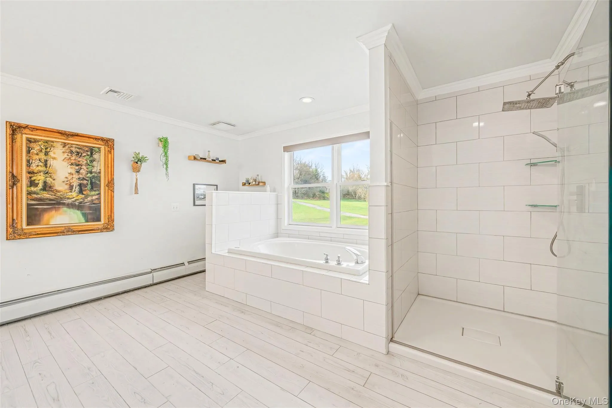 Spa-like primary bath featuring a soaking tub, separate glass-enclosed shower, and a bright, airy design. Spa-like primary bath featuring a soaking tub, separate glass-enclosed shower, and a bright, airy design.