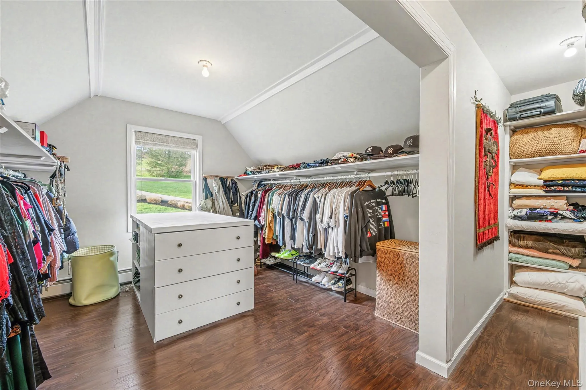 Expansive walk-in closet with ample hanging space, shelving, and room for organization. Expansive walk-in closet with ample hanging space, shelving, and room for organization.