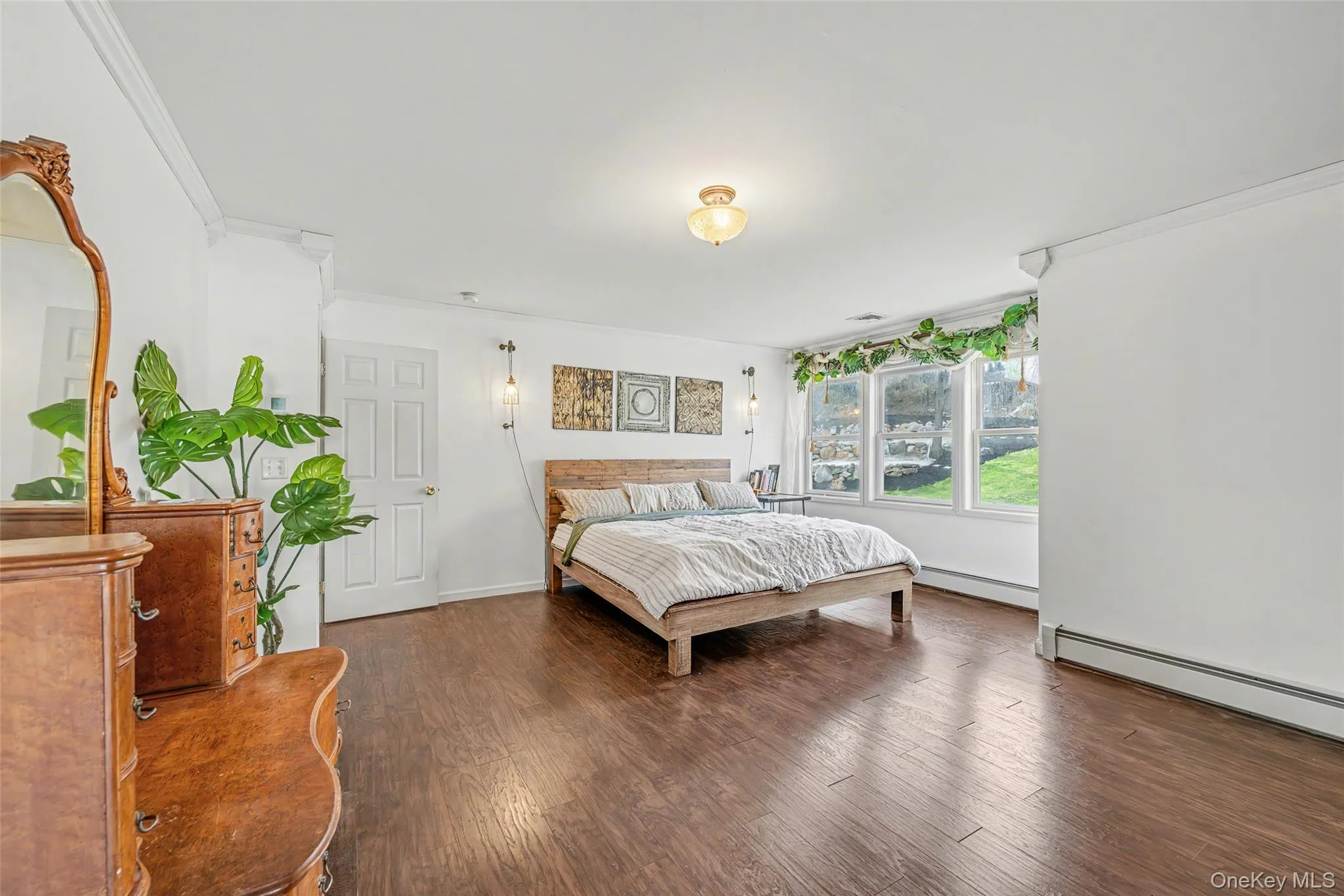 Spacious primary suite with an open layout, hardwood floors, and large windows that fill the room with natural light. Spacious primary suite with an open layout, hardwood floors, and large windows that fill the room with natural light.