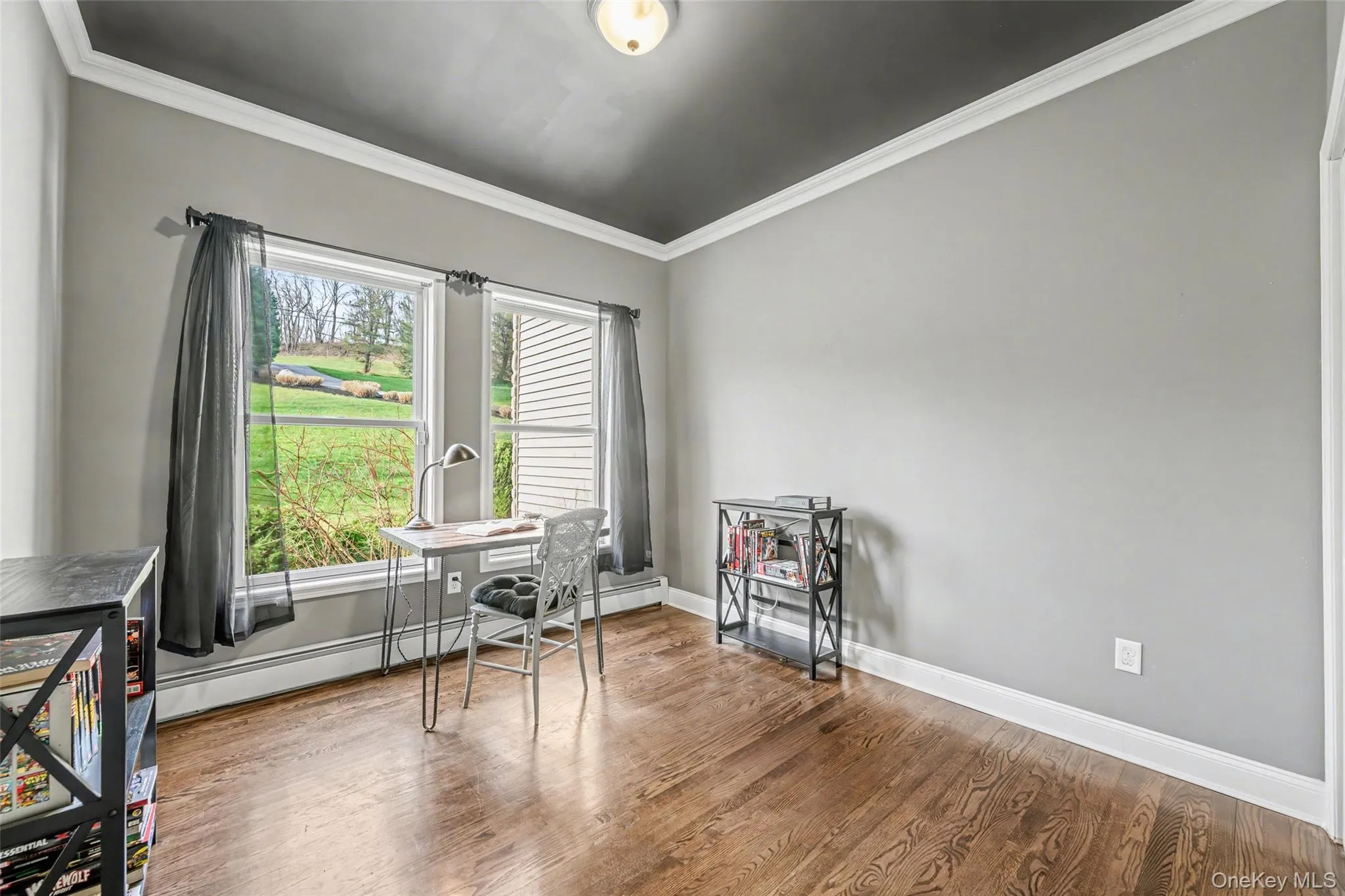 Main floor office/den featuring hardwood floors and peaceful views. Ideal for guests, a home office, or flexible living space. Main floor office/den featuring hardwood floors and peaceful views. Ideal for guests, a home office, or flexible living space.