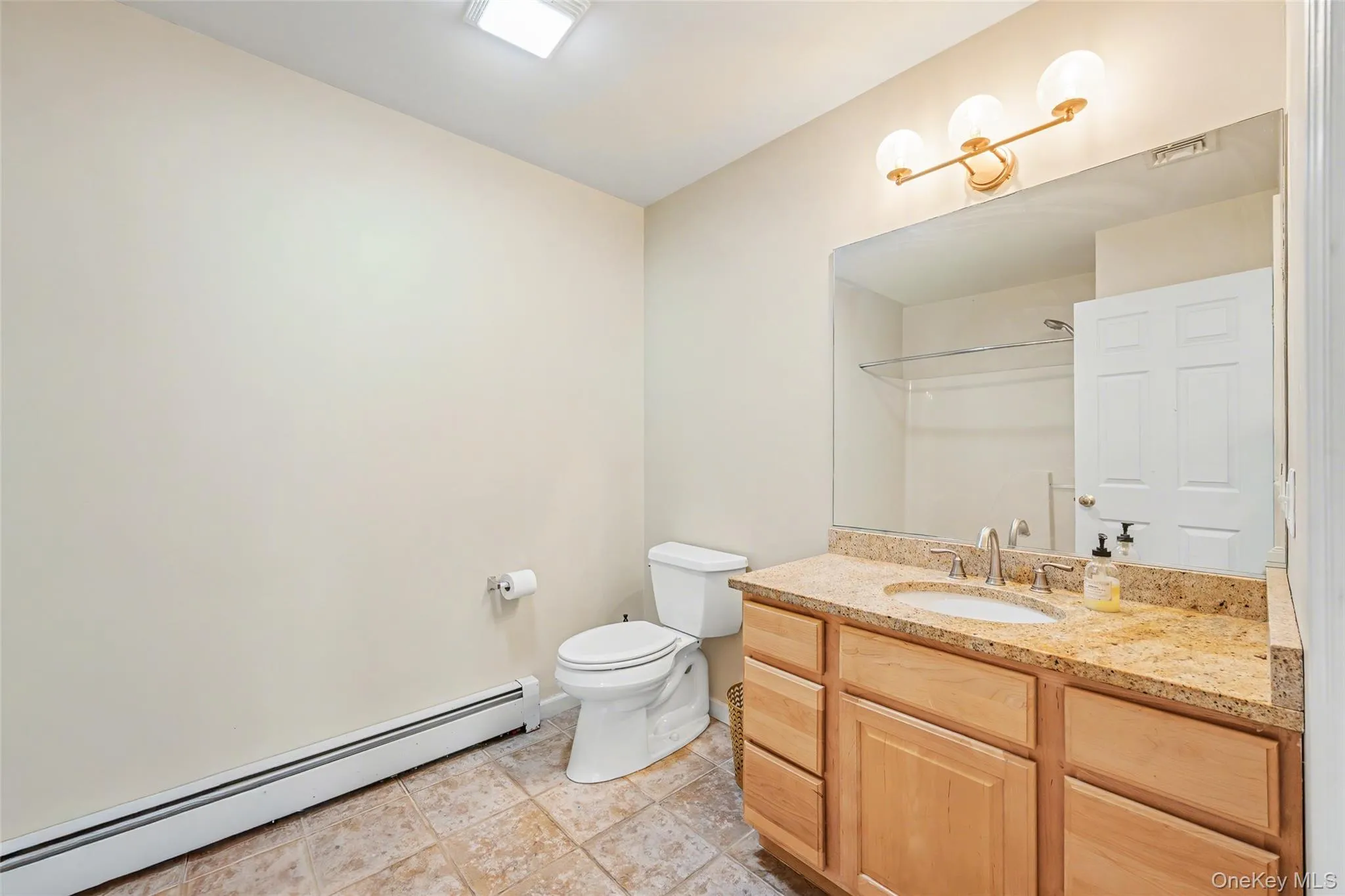 Full hall bathroom with a spacious vanity, granite countertop, and clean, functional design. Full hall bathroom with a spacious vanity, granite countertop, and clean, functional design.