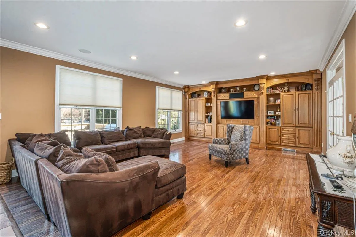 Living area featuring visible vents, recessed lighting, crown molding, and light wood-style floors Living area featuring visible vents, recessed lighting, crown molding, and light wood-style floors