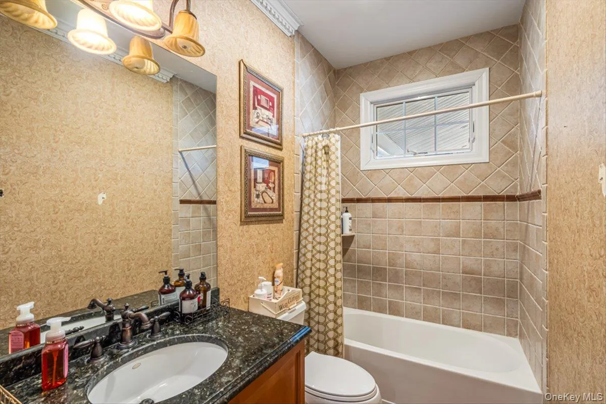 Full bathroom featuring shower / bathtub combination with curtain, toilet, and vanity Full bathroom featuring shower / bathtub combination with curtain, toilet, and vanity