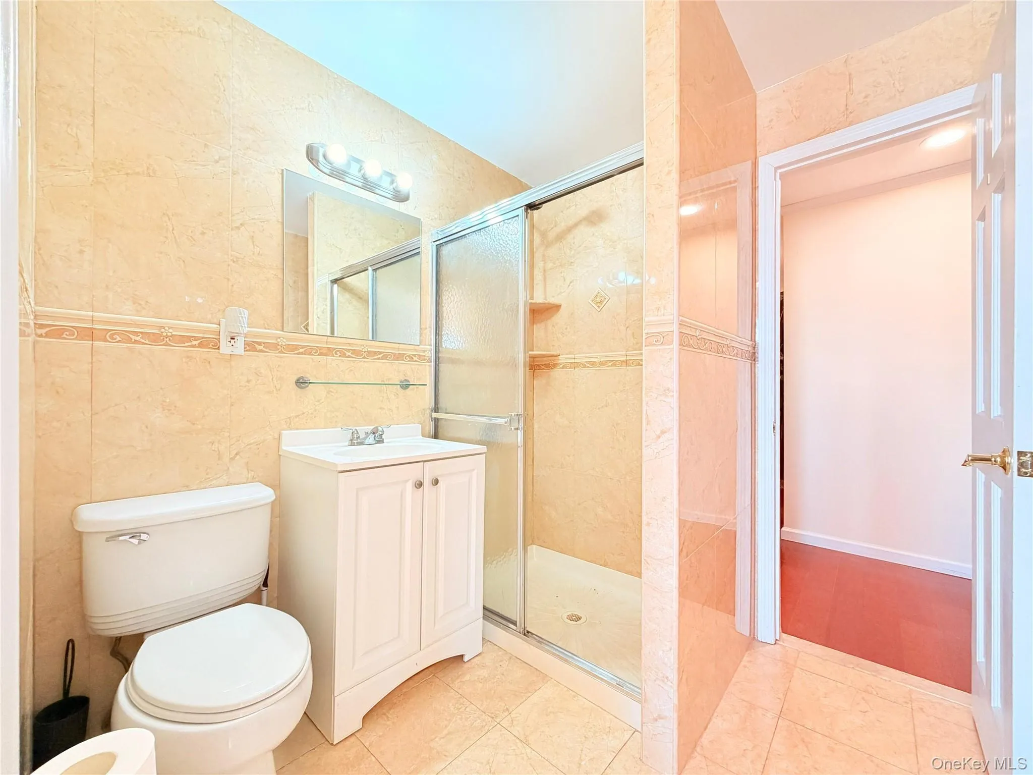 Full bath with vanity, a shower stall, and light tile patterned flooring Full bath with vanity, a shower stall, and light tile patterned flooring