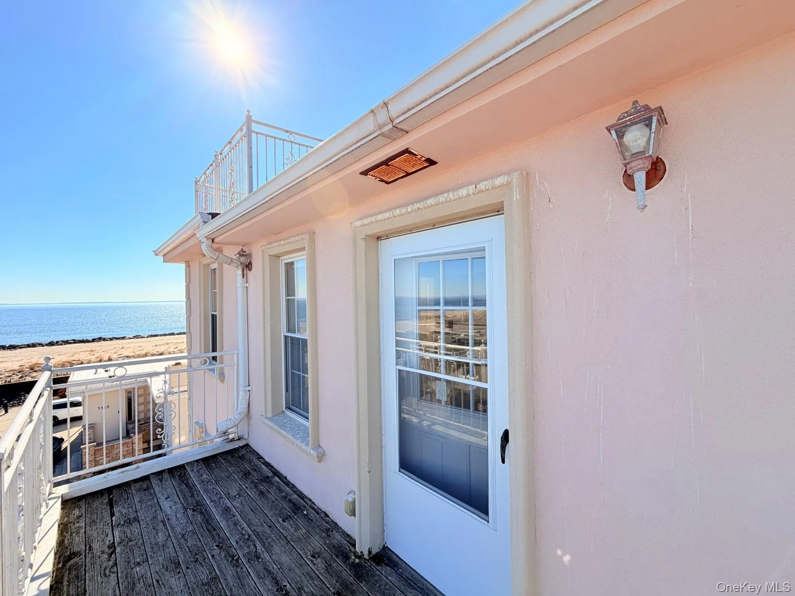 Property entrance featuring a water view and stucco siding Property entrance featuring a water view and stucco siding
