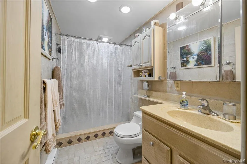 Bathroom featuring a stall shower, vanity, light tile patterned flooring, and recessed lighting Bathroom featuring a stall shower, vanity, light tile patterned flooring, and recessed lighting