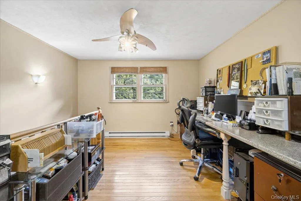 Office with light wood-type flooring, a ceiling fan, and a baseboard radiator Office with light wood-type flooring, a ceiling fan, and a baseboard radiator
