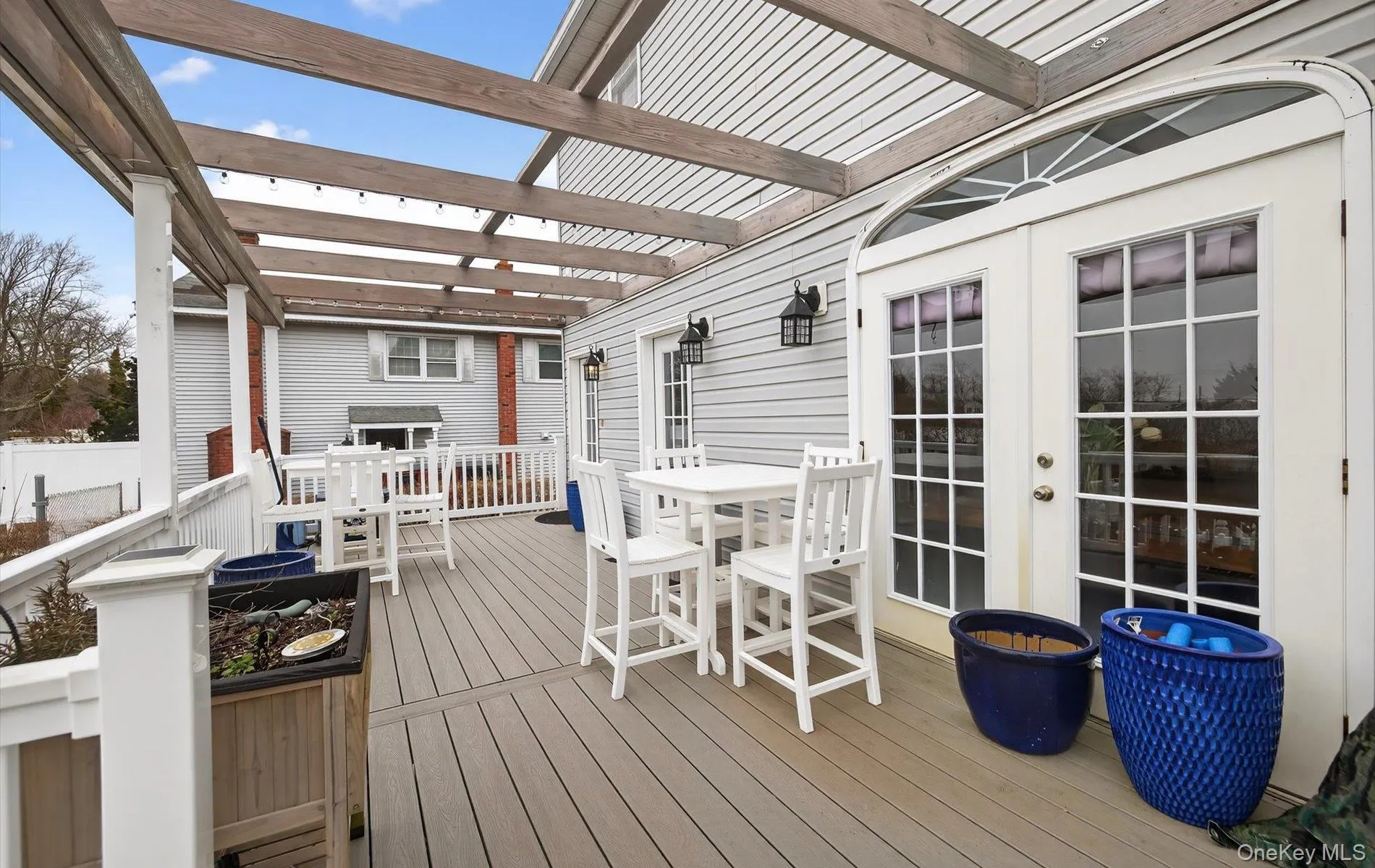 Wooden terrace featuring outdoor dining area and french doors Wooden terrace featuring outdoor dining area and french doors