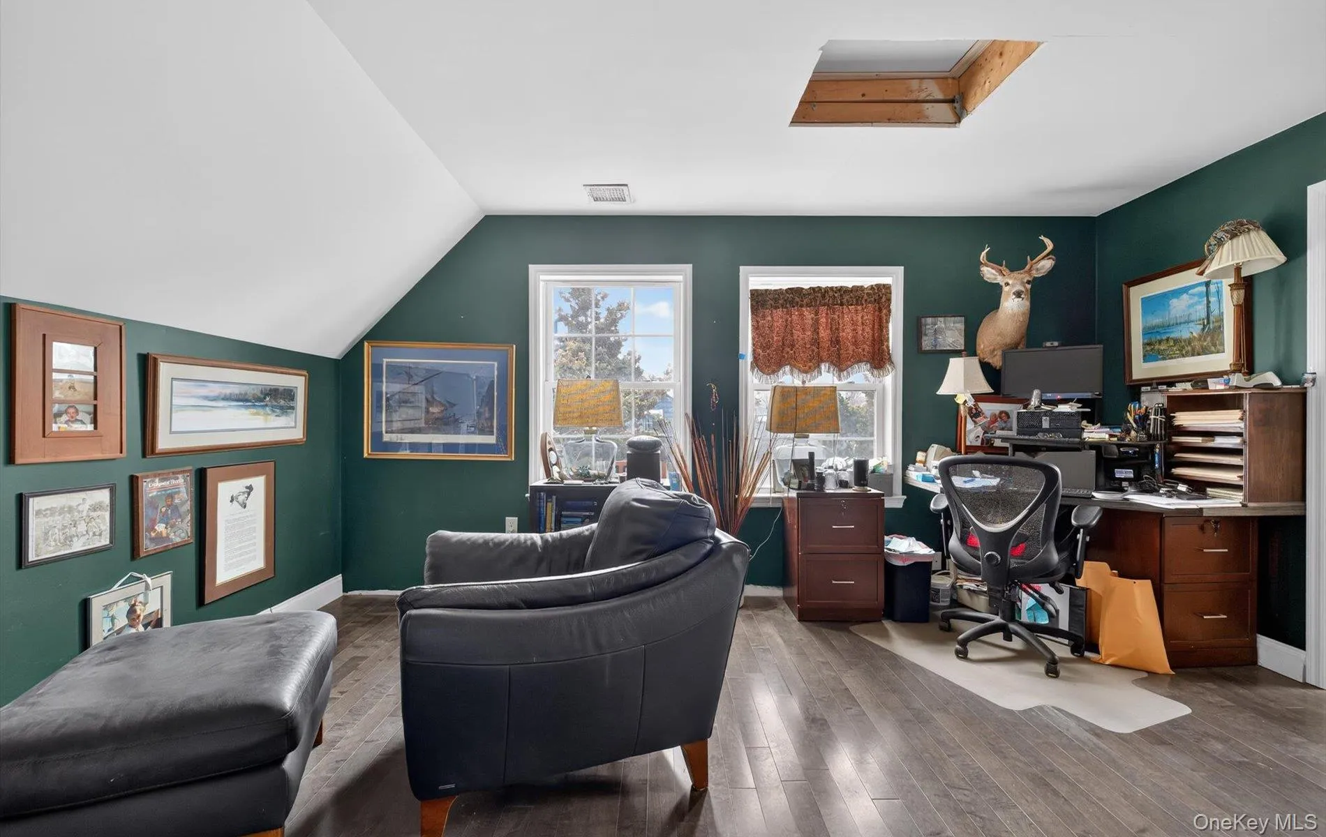 Home office featuring hardwood / wood-style floors and lofted ceiling Home office featuring hardwood / wood-style floors and lofted ceiling