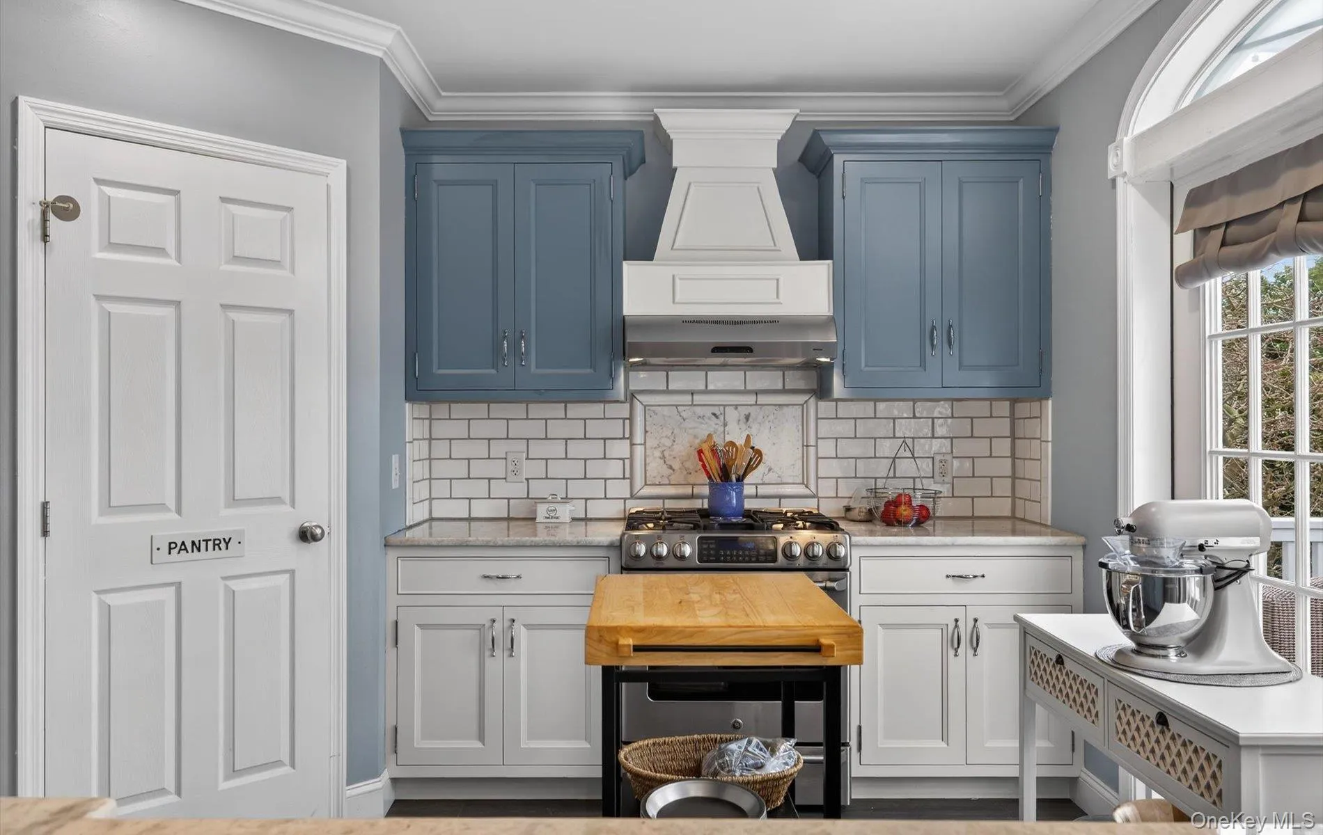 Kitchen with light stone counters, crown molding, tasteful backsplash, and stainless steel range with gas stovetop Kitchen with light stone counters, crown molding, tasteful backsplash, and stainless steel range with gas stovetop