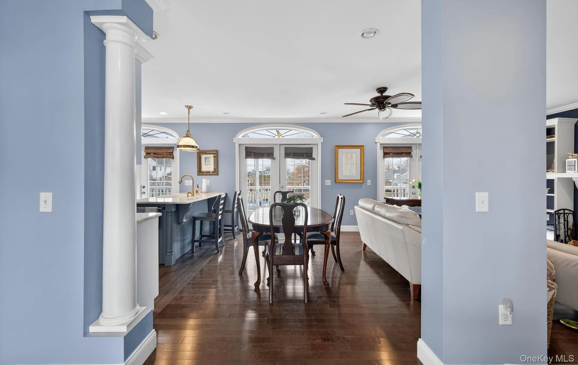 Dining space featuring decorative columns, dark wood finished floors, ornamental molding, recessed lighting, and a ceiling fan Dining space featuring decorative columns, dark wood finished floors, ornamental molding, recessed lighting, and a ceiling fan