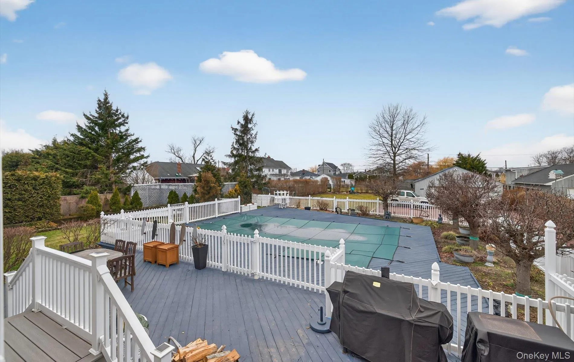 View of pool with a fenced backyard, a residential view, a deck, and grilling area View of pool with a fenced backyard, a residential view, a deck, and grilling area