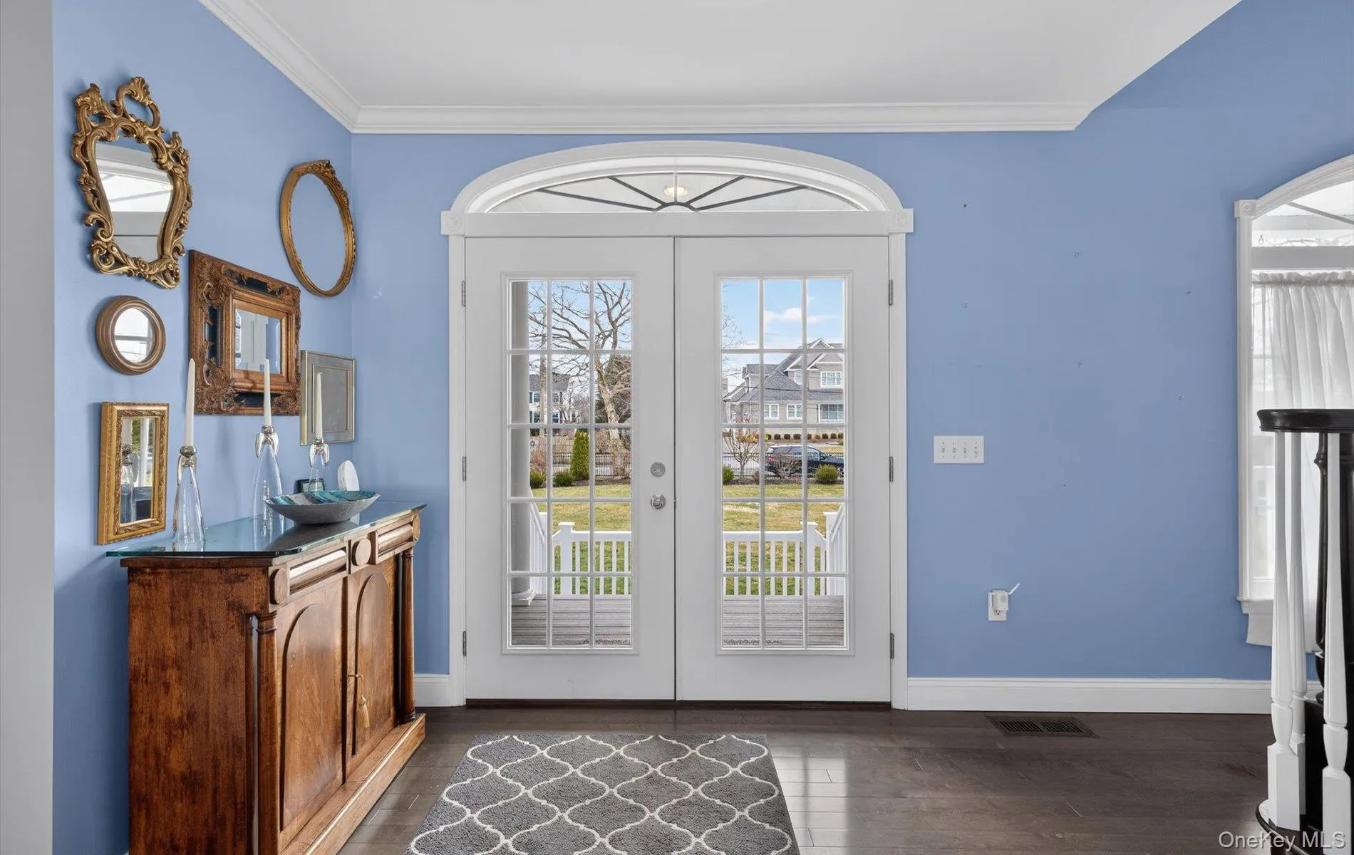 Doorway featuring ornamental molding, wood finished floors, and french doors Doorway featuring ornamental molding, wood finished floors, and french doors