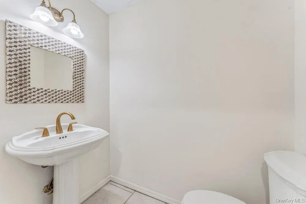 Half bathroom with toilet and light tile patterned floors Half bathroom with toilet and light tile patterned floors
