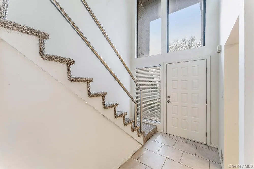 Foyer with light tile patterned flooring and a high ceiling Foyer with light tile patterned flooring and a high ceiling