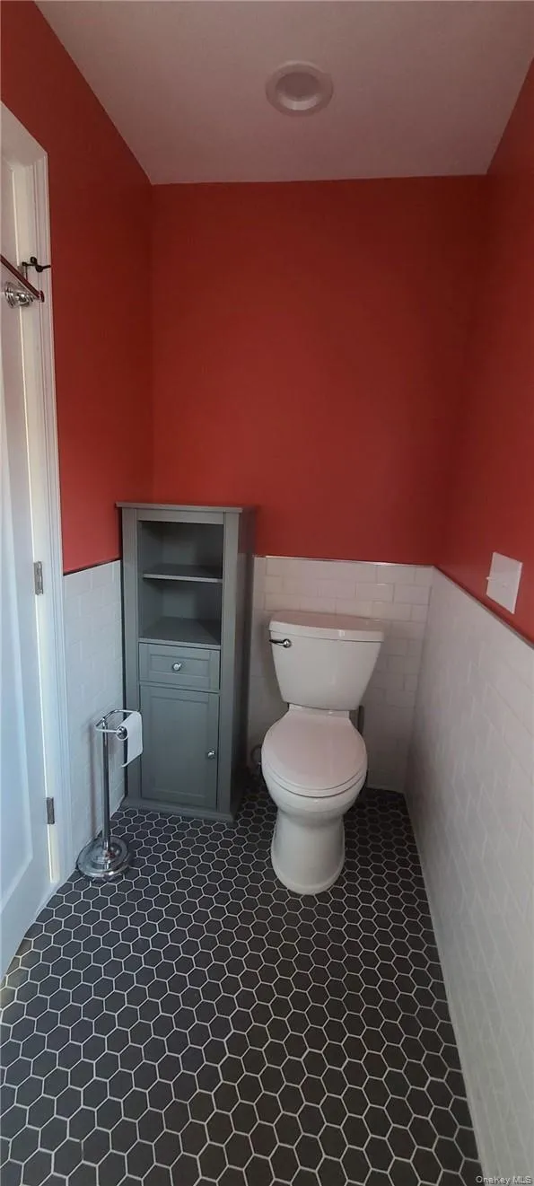 Bathroom featuring tile floors, toilet, and heated tile walls Bathroom featuring tile floors, toilet, and heated tile walls