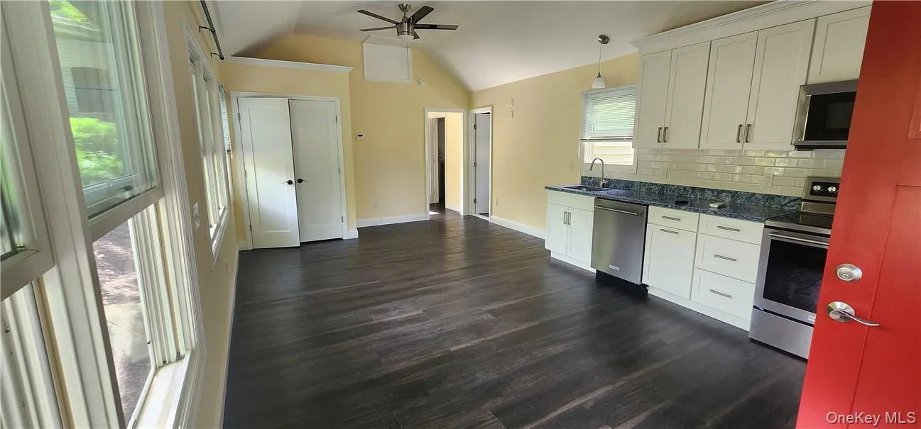Kitchen featuring stainless steel appliances, Quartz countertop tasteful engineered flooring, white cabinets, and sink Kitchen featuring stainless steel appliances, Quartz countertop tasteful engineered flooring, white cabinets, and sink