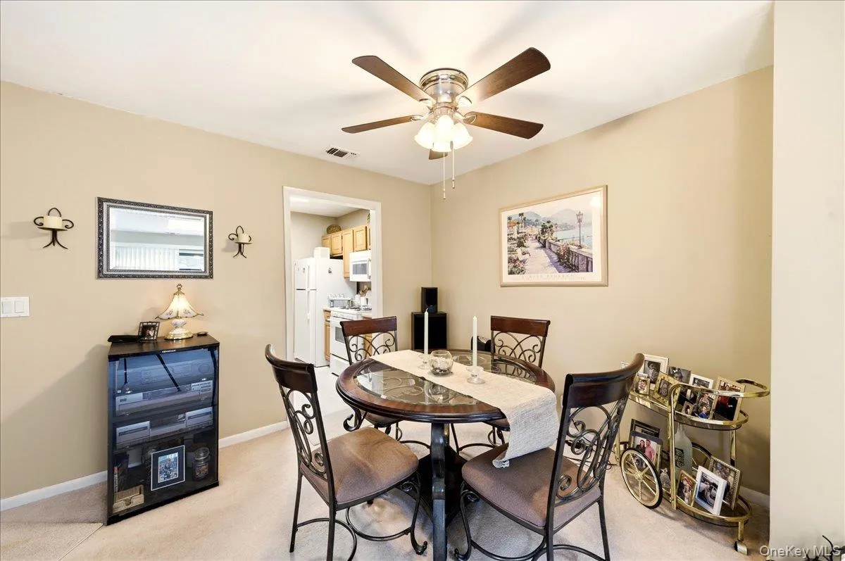 Dining area featuring light carpet and ceiling fan Dining area featuring light carpet and ceiling fan