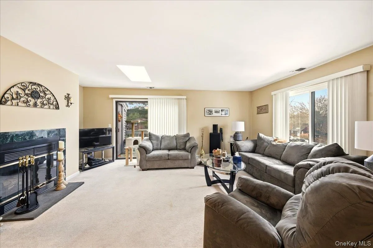 Carpeted living area featuring a high end fireplace Carpeted living area featuring a high end fireplace