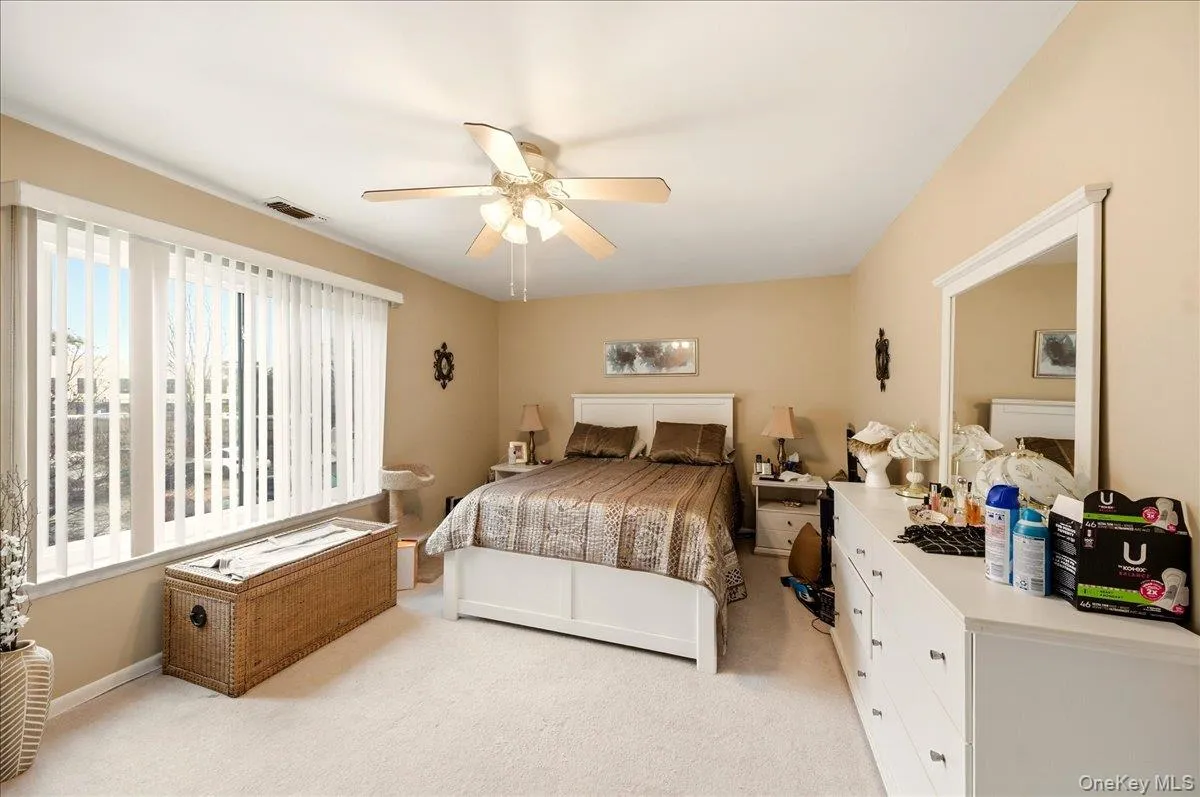 Bedroom featuring light colored carpet and a ceiling fan Bedroom featuring light colored carpet and a ceiling fan