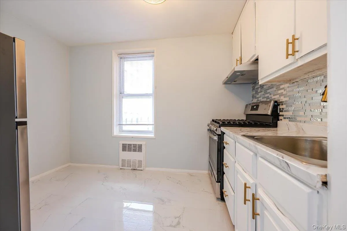 Kitchen features new stainless steel appliances, rangehood, decorative tiled backsplash, tiled flooring, light fixture and countertops. Kitchen features new stainless steel appliances, rangehood, decorative tiled backsplash, tiled flooring, light fixture and countertops.