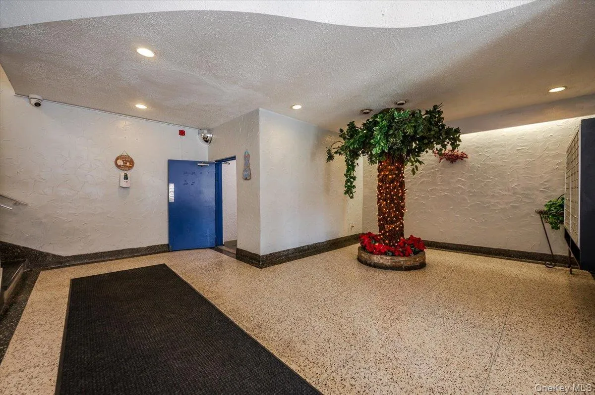 Lobby featuring a textured wall, recessed lighting, and a textured ceiling Lobby featuring a textured wall, recessed lighting, and a textured ceiling