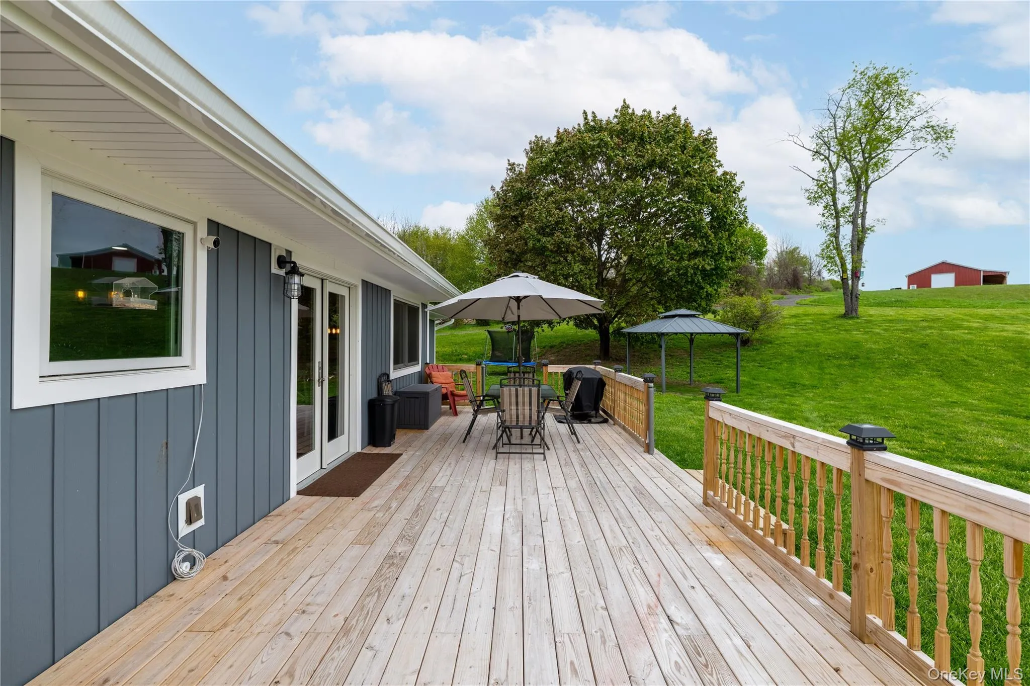 Spacious wooden deck with natural wood railing and integrated post cap lighting Spacious wooden deck with natural wood railing and integrated post cap lighting