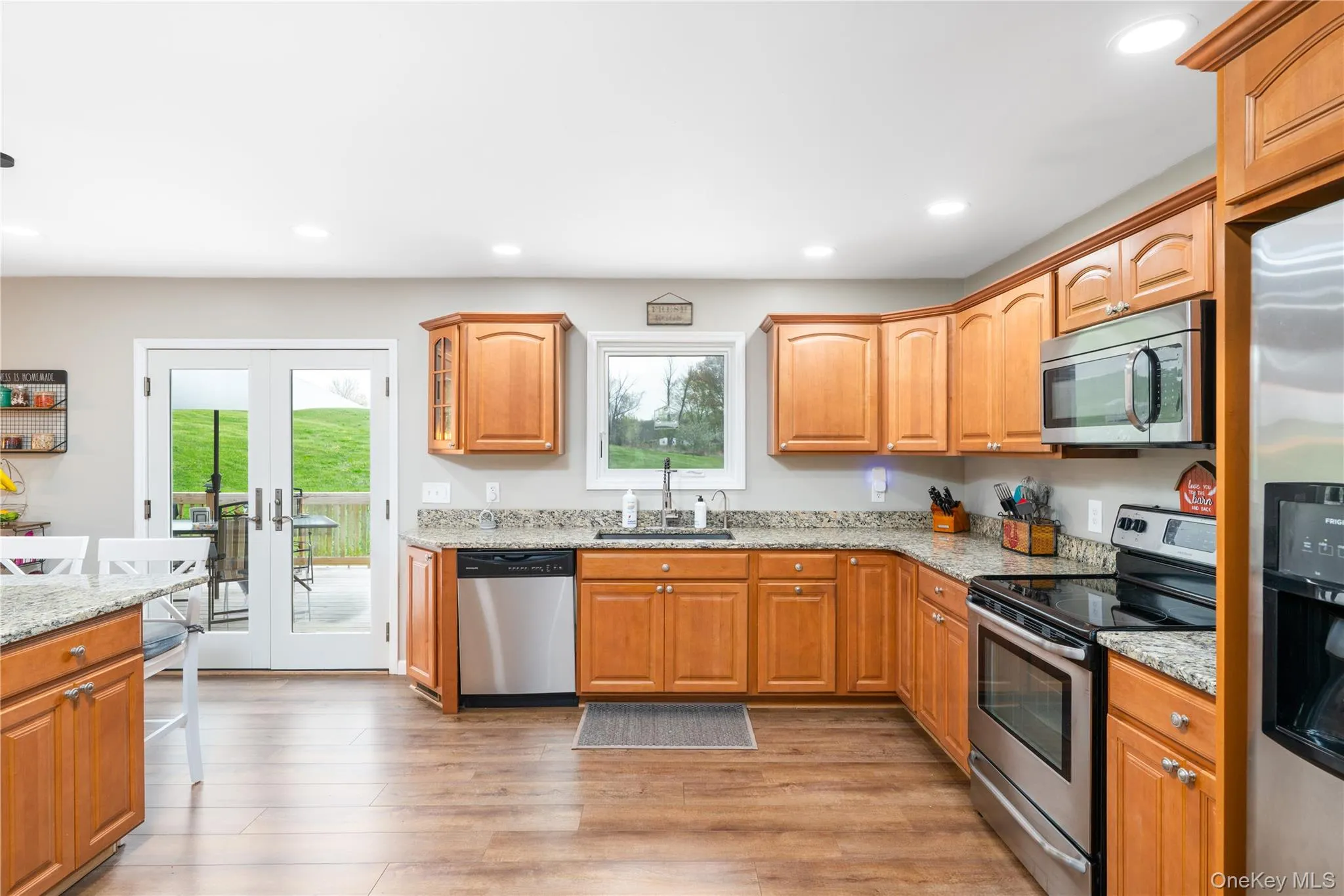 Kitchen featuring wood flooring, light wood cabinetry, granite countertops, stainless steel appliances, and recessed lighting Kitchen featuring wood flooring, light wood cabinetry, granite countertops, stainless steel appliances, and recessed lighting