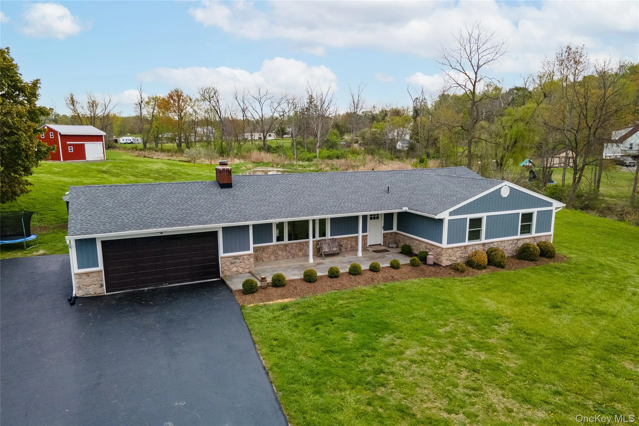 Ranch-style residence featuring royal composite gray-blue siding and stone veneer accents Ranch-style residence featuring royal composite gray-blue siding and stone veneer accents