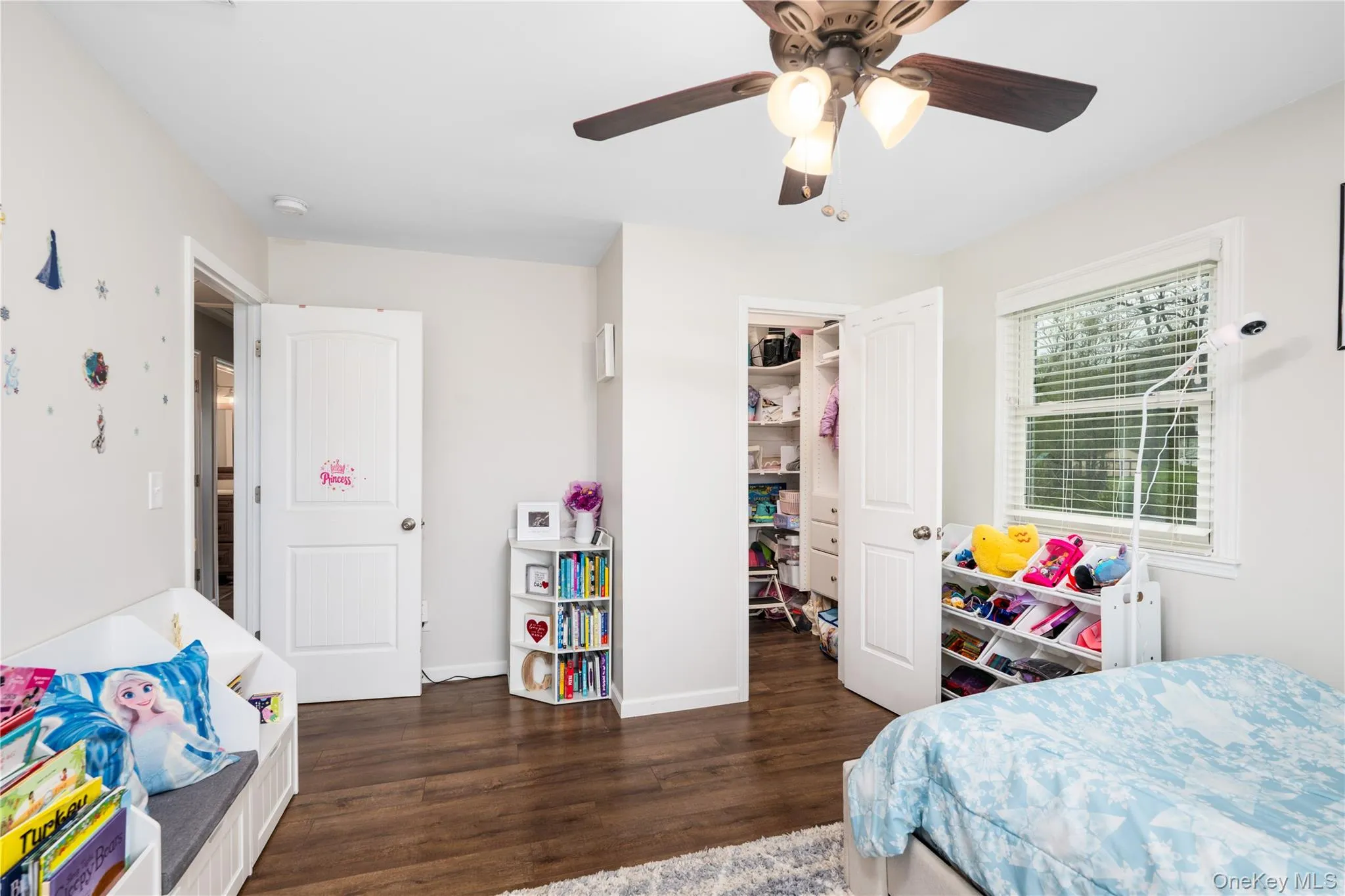 Bedroom 2- featuring wood flooring, a ceiling fan with integrated lighting, and a window with blinds Bedroom 2- featuring wood flooring, a ceiling fan with integrated lighting, and a window with blinds