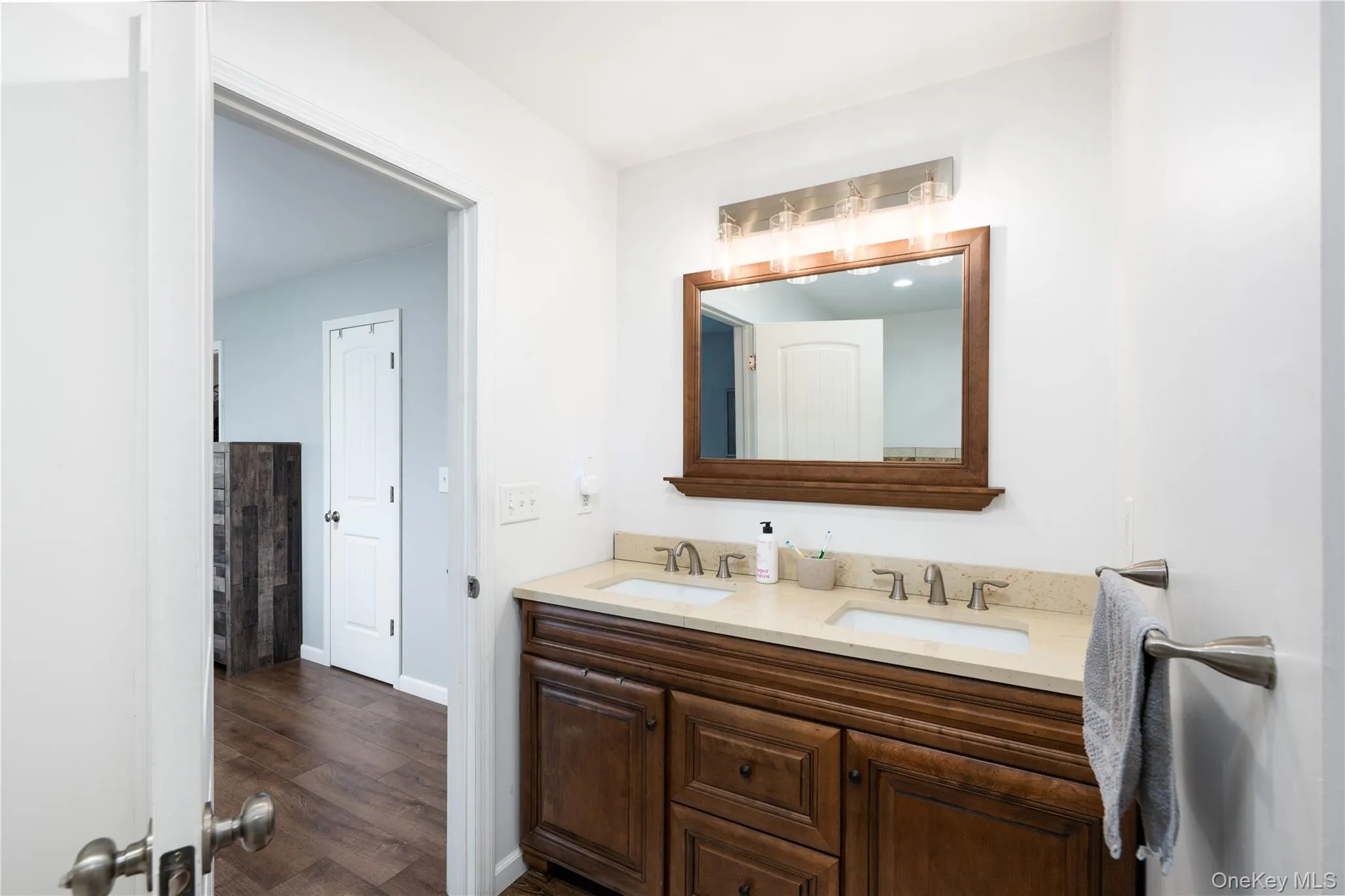 Ensuite Bathroom featuring a dual-sink Quartz vanity, a framed mirror, and a multi-bulb light fixture Ensuite Bathroom featuring a dual-sink Quartz vanity, a framed mirror, and a multi-bulb light fixture