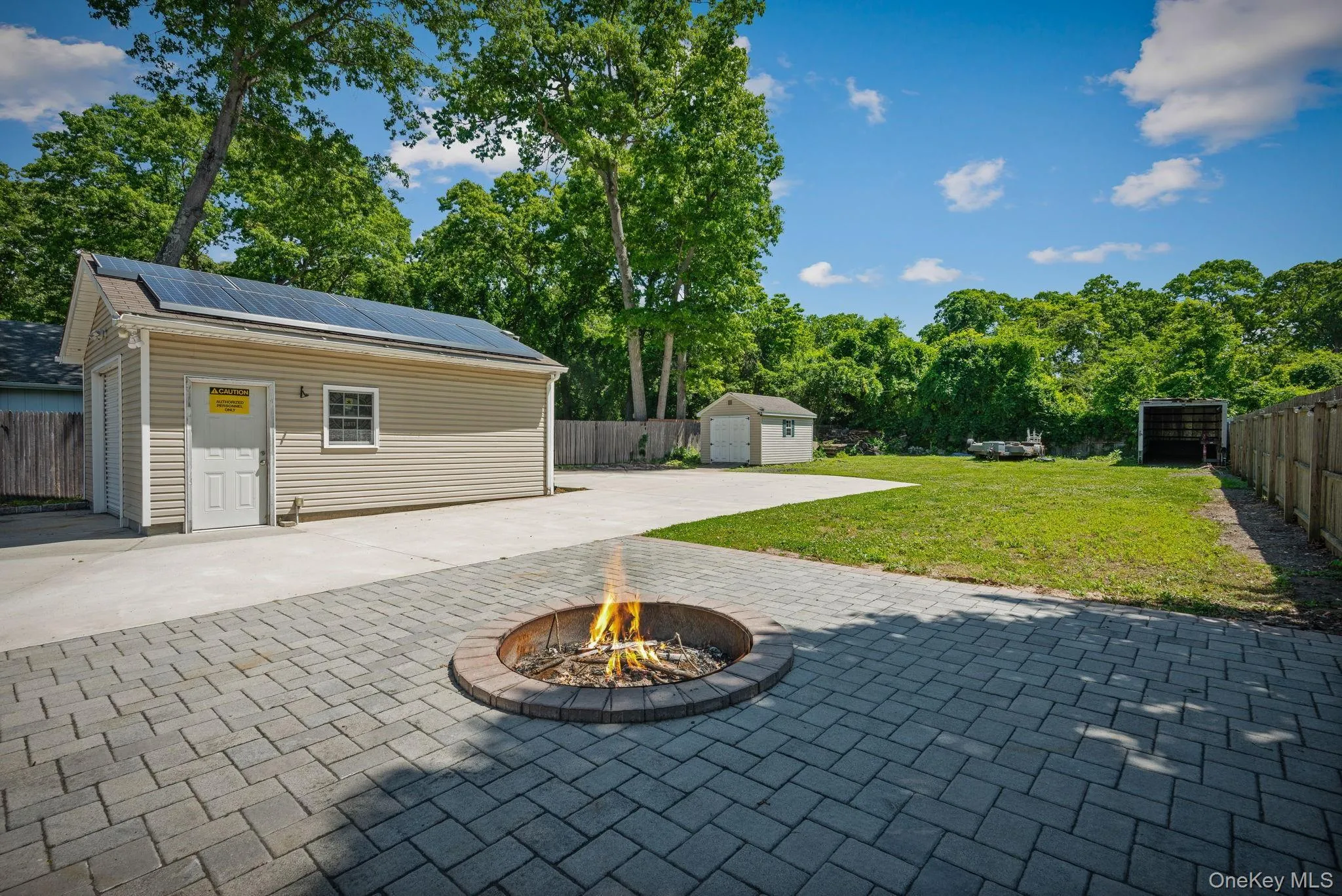 Paver patio featuring a circular fire pit in front of the detached garage Paver patio featuring a circular fire pit in front of the detached garage