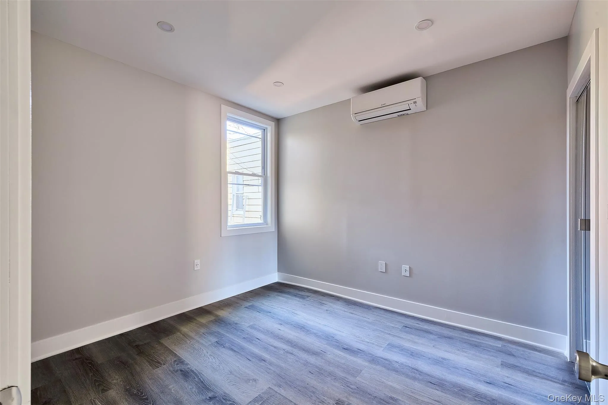 Unfurnished room featuring wood finished floors and a mini split for heating / cooling Unfurnished room featuring wood finished floors and a mini split for heating / cooling