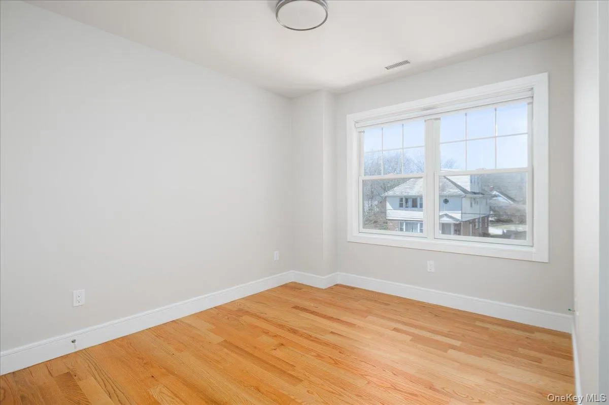 Spare room with baseboards, visible vents, and wood finished floors Spare room with baseboards, visible vents, and wood finished floors