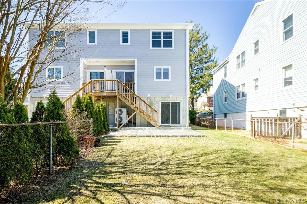 Back of property featuring a fenced backyard, a patio area, stairs, and a lawn Back of property featuring a fenced backyard, a patio area, stairs, and a lawn